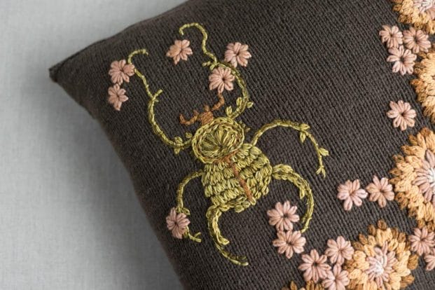 Embellish a hand knit cushion with embroidery.