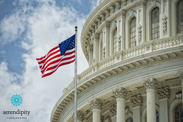 Washington DC Capitol dome detail with American flag waving in the breeze.