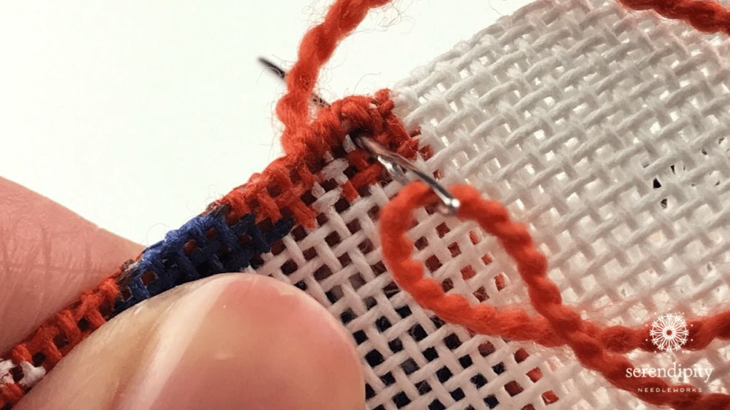 Go back three stitches and insert your needle through the canvas.