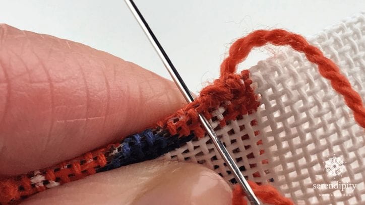 Then, move up to the next available canvas hole and insert your needle to make the second portion of the binding stitch.