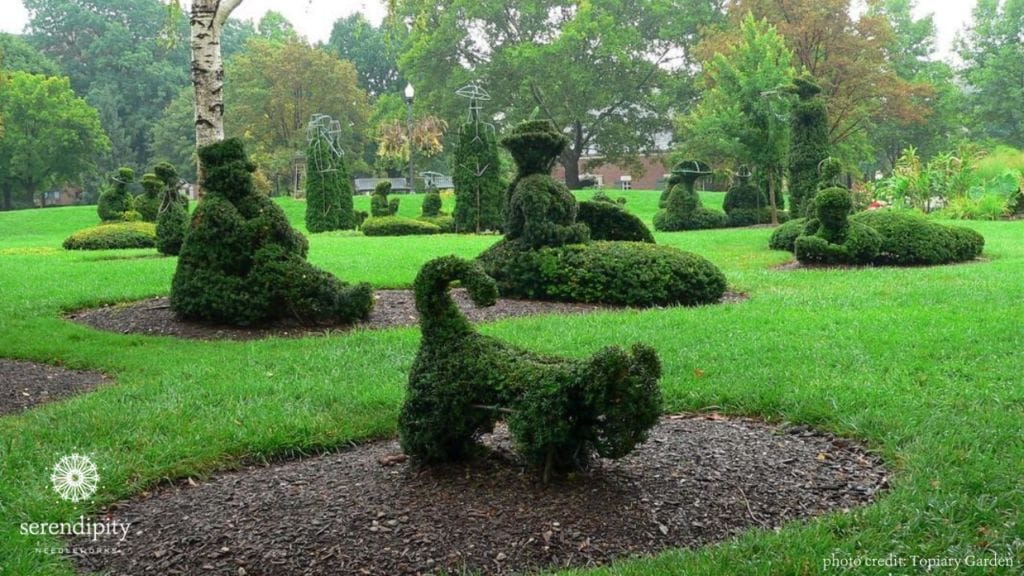 Topiaries in the garden represent subjects in Seurat's painting
