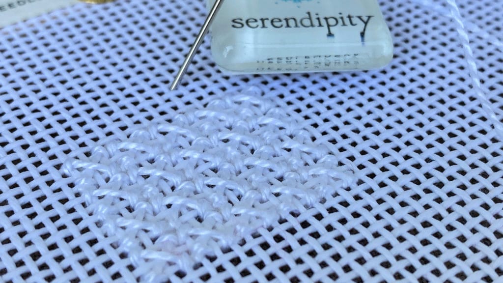 The sample of the rice stitch is worked in white pearl cotton #5.